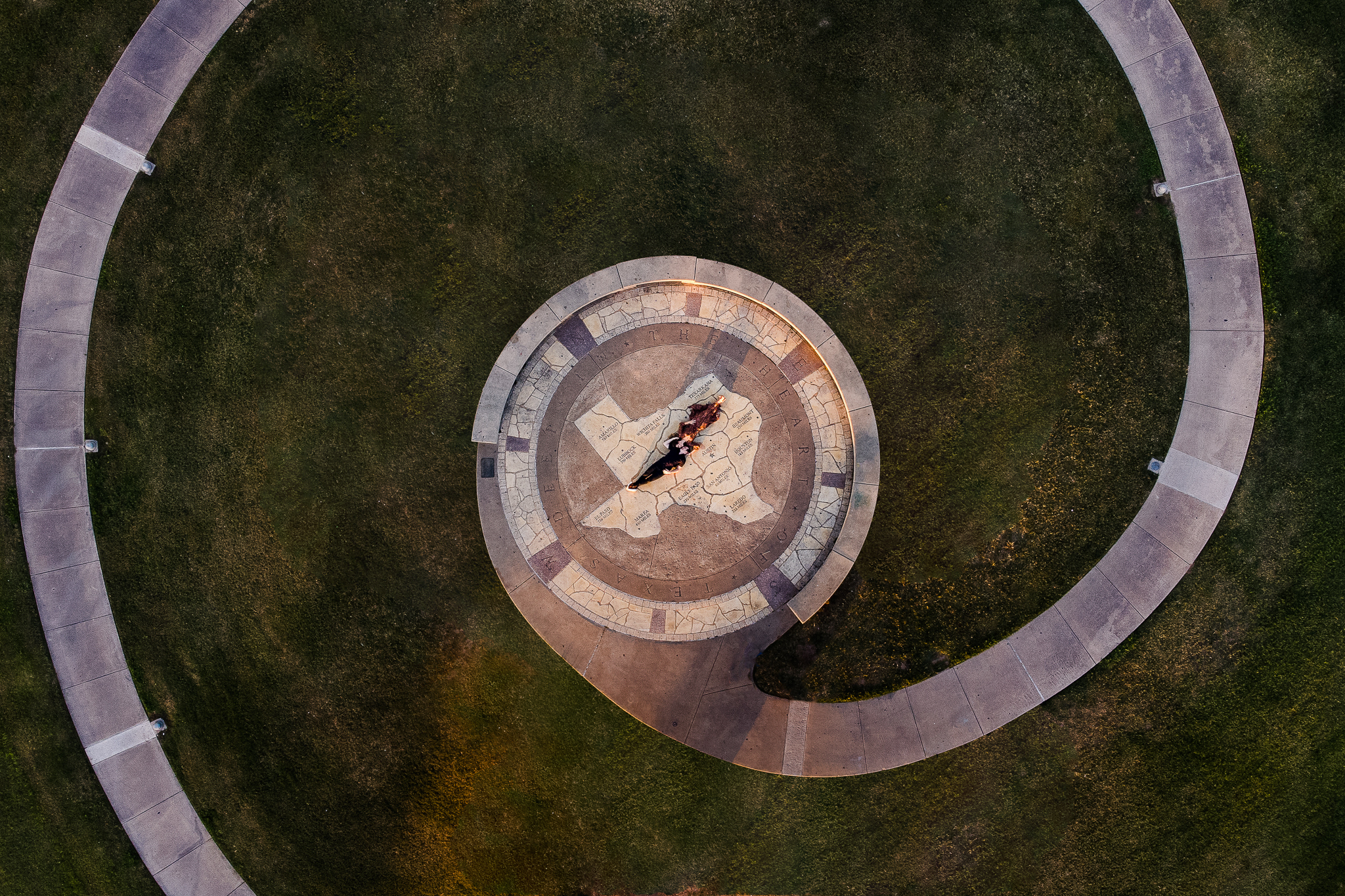couple lays on top of texas-shaped masonry atop doug sahm hill in Austin